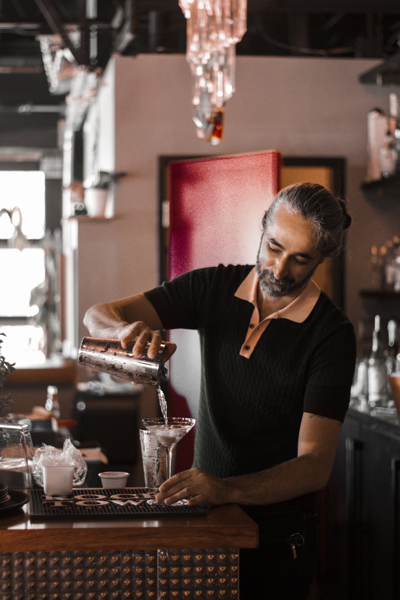 Bartender pouring a martini at the Bottega bar
